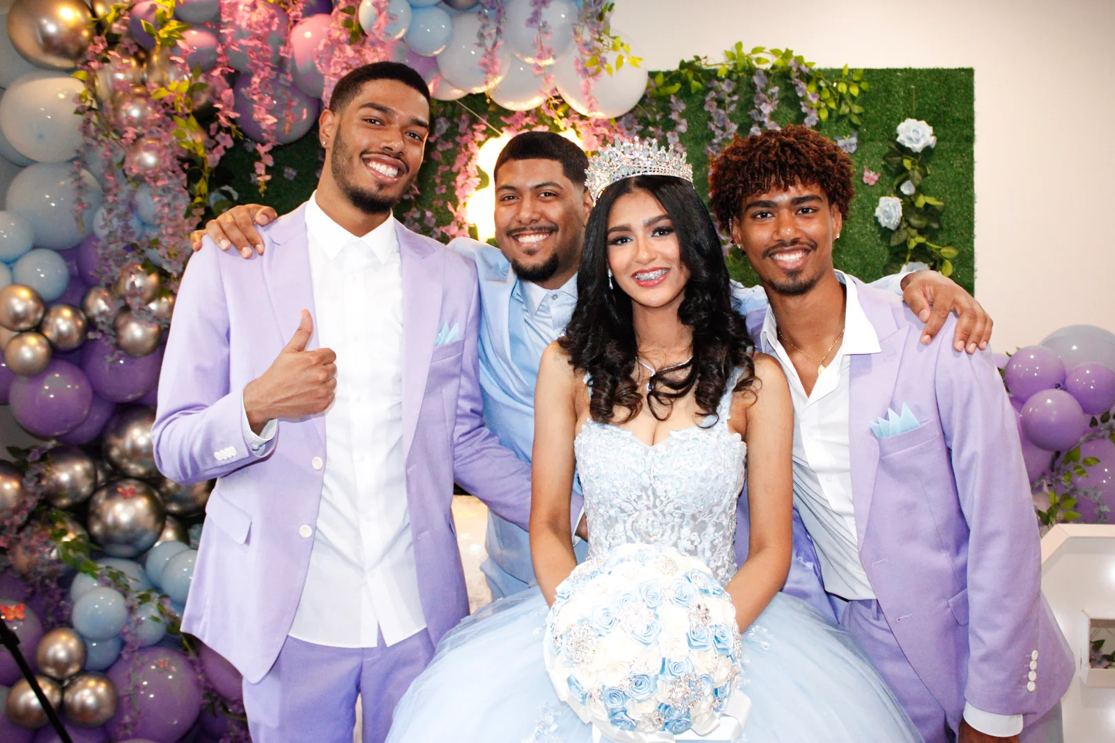 The celebrant in a pale blue gown with three guests in lilac jackets