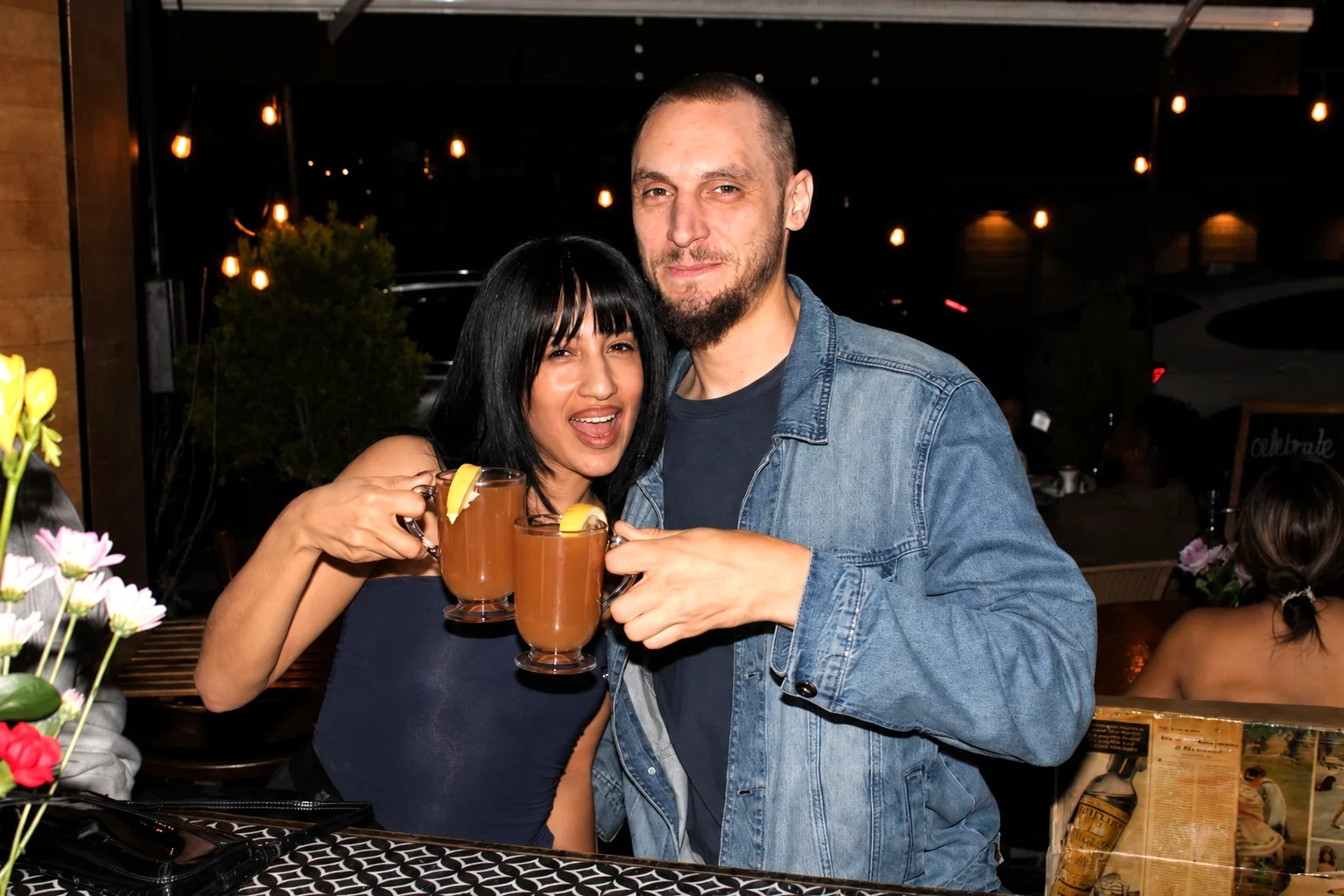 Two guests raising drinks for an evening restaurant portrait at The Ox Tavern at Westwood