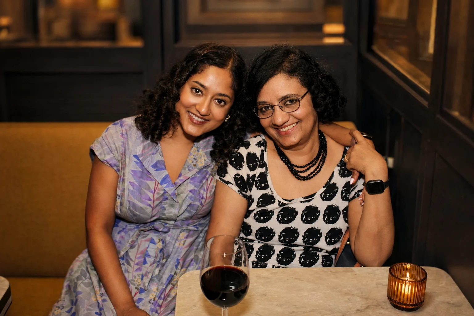 Two guests standing arm in arm beside a candlelit restaurant table at The Ox Tavern at Westwood