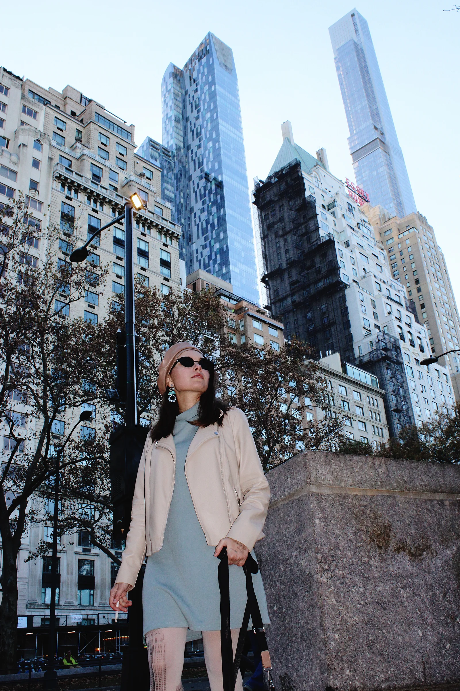 A portrait framed by trees and tall New York City buildings