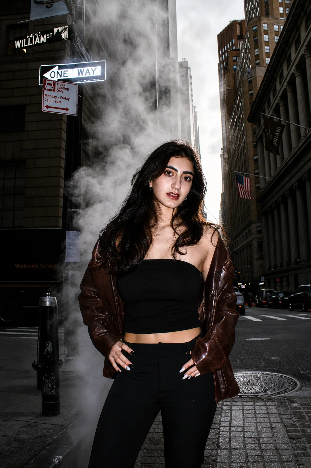 A street portrait beneath a William Street sign with steam in the background