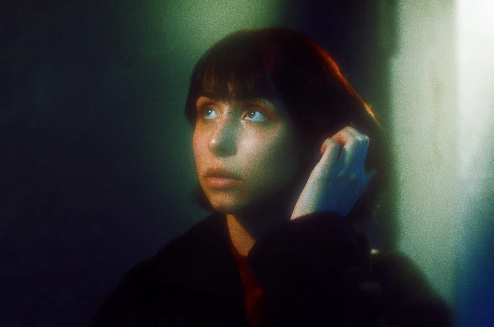 A close-up editorial portrait with warm and teal light